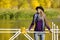 Girl in hat standing on the dock. Autumn, sunny. Portrait