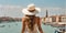 A girl in a hat sundress summer traveler back to the camera romantic of Venice