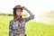 Girl with hat wearing shirt in a field with water sprinklers