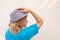 Girl in hat. White middle aged woman poses under sun beams. Profile portrait with calm face