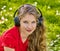 Girl in headphones catch rhythm music on green grass