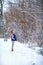 Girl in headphones near a bird feeder in winter in Park