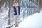 Girl in headphones near fence in winter in Park