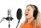 Girl in headphones singing with studio microphone