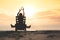 Girl in headphones is sitting on the sun lounger listening to music on the beach at sunset.