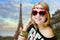 Girl in heart shaped sunglasses on blurred Eiffel