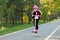 A girl in a helmet makes a jump on a scooter. Active children`s games outside