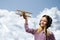 Girl in helmet pilot playing with a toy airplane