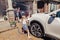 girl helping father wash car on driveway in front house on summer day