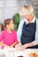 Girl helping grandmother baking