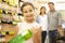 Girl helping parents with supermarket shopping