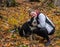 Girl and her dog cuddling during an autumn trail hike