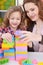 Girl and her mother playing colorful plastic blocks