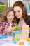 Girl and her mother playing colorful plastic blocks