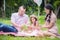 Girl with her parent sitting in park and watching flower