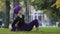 Girl in hijab muslim woman sports lady female yogi sitting in city park on grass lawn holds foot under arm doing