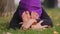 Girl in hijab sportive calm mindful woman sitting on green grass lawn in city park outdoors doing stretching legs bends