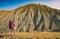 Girl hiker with backpack standing against badland