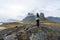 Girl in hiker clothes are looking towards the famous Eystrahorn mountain chains