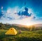 Girl hiker sitting near yellow tourists tent