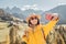 Girl hiker walks along a special recreational trail high in the Alpine mountains. A cozy little village and rocky cliffs in