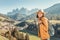 Girl hiker walks along a special recreational trail high in the Alpine mountains. A cozy little village and rocky cliffs in