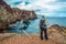 Girl hiking rocky cliffs clear near water of Atlantic Ocean bay Ponta de Sao Lourenco, the island of Madeira, Portugal