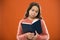 Girl hold book read story over orange background. Child enjoy reading book. Book store concept. Wonderful free childrens