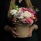 A girl is holding a beautiful bouquet of exclusive fresh flowers in a box. A great gift for women`s day, Valentine`s Day