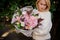 Girl holding a beautiful bouquet of tender pink autumn flowers