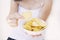 A girl holding the big potato chips bowl. Asking to eating together