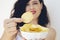 A girl holding the big potato chips bowl. Asking to eating together