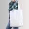 Girl is holding blank cotton tote bag, design mockup.