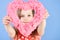 Girl holding blurred pink heart on blue background