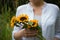 Girl holding a bouquet of sunflowers outdoor.