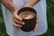 The girl holding a clay Cup of hot cappuccino closeup