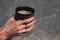 The girl holding a clay Cup of hot cappuccino closeup