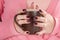 Girl holding cup of tea in hand with red wine color manicure nails polish