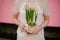 Girl holding a cute pot with a toy lamb with a yellow narcissus