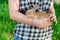 A girl is holding a cute red-haired rabbit asleep in her arms, in a park in nature. Close-up.