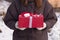 The girl is holding a gift tied with a white and red ribbon. Happy birthday congratulation concept