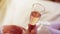 The girl is holding a glass of champagne. Close up. In the glass visible bubbles of gases.