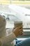 Girl is holding a glass of coffee in airport`s business lounge with aircraft