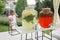 Girl holding a glass of colorful natural fruits lemonade during backyard barbeque party at summer