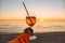 Girl Holding Glass of Drink on Beach at Beautyfull Romantic Sunset. Glass and Hand Close Up