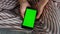 Girl holding green mobile in hands closeup. Teenager watch online blogs morning