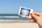 Girl Holding Instant Photo Of Sea Beach