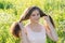 Girl holding long hair on flower meadow