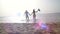 Girl holding male hand and running on tropical exotic beach to the ocean. Follow me shot of young woman pull her