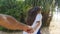 Girl holding male hand and running on tropical exotic beach to the ocean. Follow me shot of young woman pull her